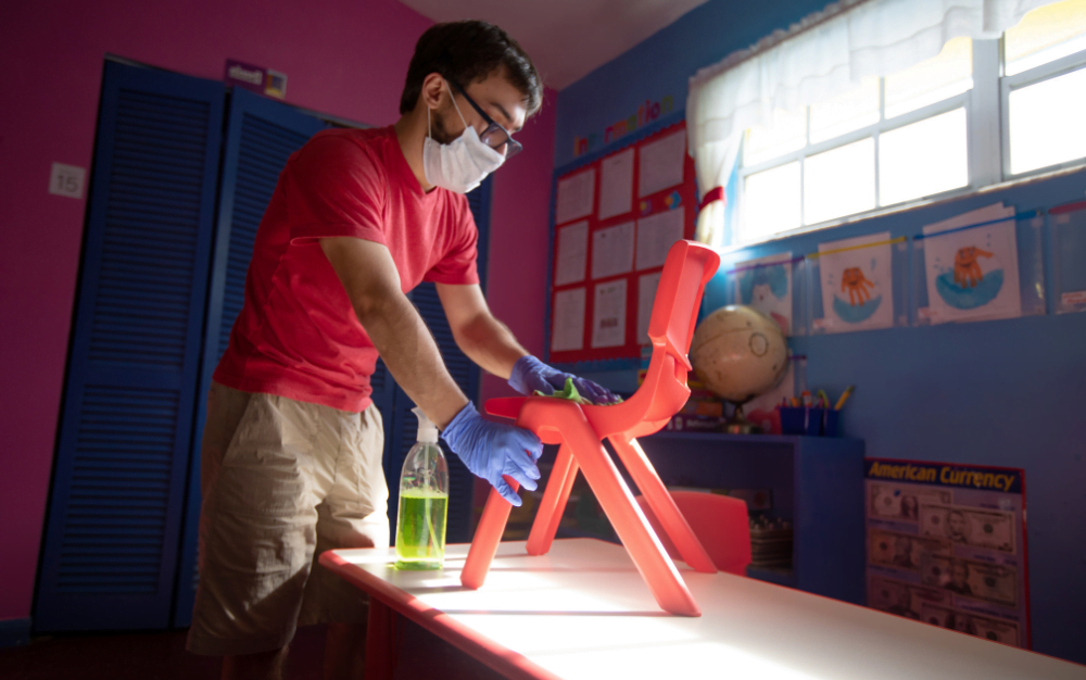 Trabajador de Grupo Rojas limpiando clase de colegio en Madrid